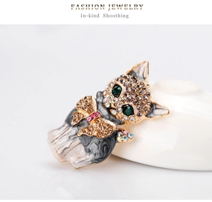 Macro view of crystal feline brooch with green emerald eyes and enamel finish