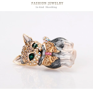 Detailed close-up of a golden cat brooch with green crystal eyes and enamel marble texture