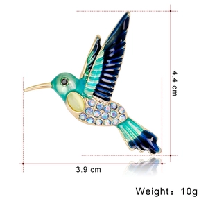 Modische Kolibri-Brosche mit blauem Emaille und bunten Strasssteinen auf weißem Hintergrund