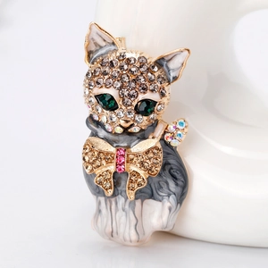 Elegant cat brooch with grey marble enamel, green crystal eyes and golden bow detail