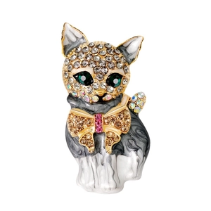 Fashionable cat brooch with green crystal eyes and rhinestone bow on a white background