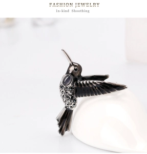 Detailaufnahme der Kolibri-Brosche mit grauen Strasssteinen und Katzenaugen-Stein