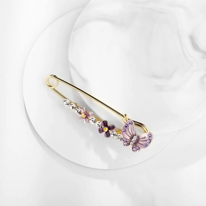 Macro shot of an elegant purple flower brooch with rhinestone butterfly details