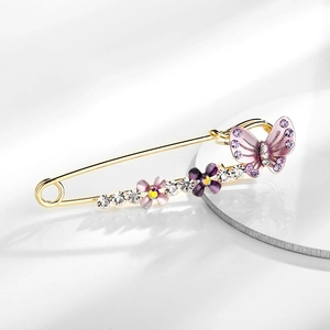 Detail of crystal butterfly brooch pin with purple gemstones and golden floral accents