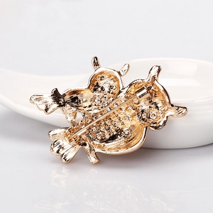 Elegant gold-tone owl brooch with dual bird design and secure pin fastener on white ceramic