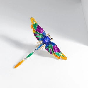 Vintage gold dragonfly brooch with colorful enamel wings and blue crystal stone