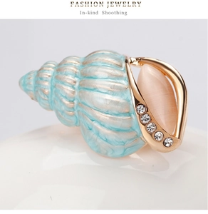 Details der hellblauen Emaille-Muschelbrosche mit rosa Opal und glitzernden Strass