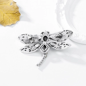 Vintage silver alloy dragonfly brooch with rhinestone details and filigree wings
