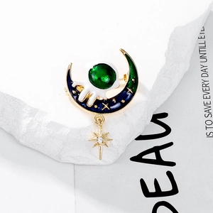 Macro detail of enamel astronaut on blue moon brooch with a dangling gold star charm