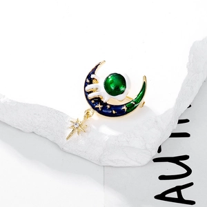 Cartoon astronaut moon enamel brooch with gold finish, blue enamel, and dangling star charm