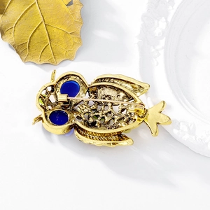 Spilla gufo vintage in oro antico con occhi blu, dettaglio del retro dell'anello