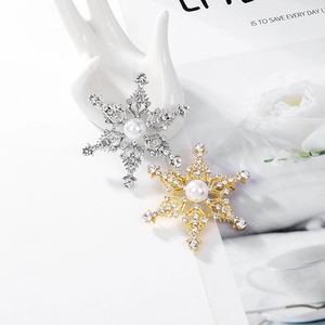 Detalle de broches de copo de nieve en aleación con pedrería brillante y perla central
