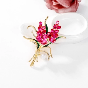 Eleganter goldener Blumenanstecker mit rosa Kristallen, grünen Blättern und Perle