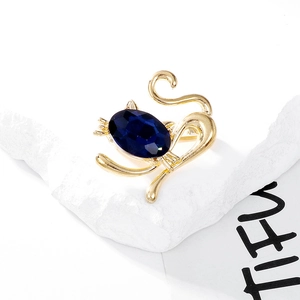 Close-up of cute cat brooch with a large deep blue crystal and golden metal frame