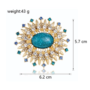 Blue glass starburst sunburst brooch with crystal rhinestones and golden metal finish