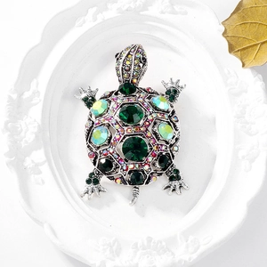 Vintage sea turtle brooch featuring green crystal shell and colorful rhinestones on silver base