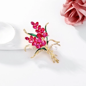 Eleganter goldener Blumenanstecker mit rosa Kristallen, grünen Blättern und Perle