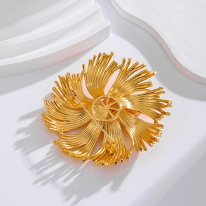 Detail view of the vintage gold flower brooch back showing the pin fastener and texture