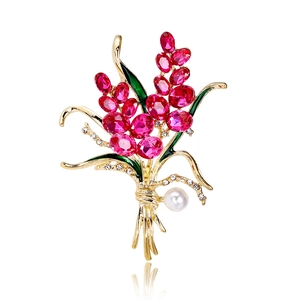 Elegant floral wheat brooch with rose red crystals, green leaves, and pearl in gold setting