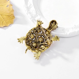 Vintage gold sea turtle brooch back view showing secure pin clasp on white tray