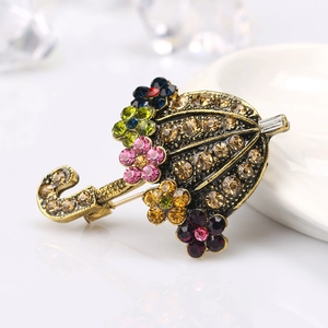 Vintage paraplubroche met kleurrijke strasstenen op een goudkleurige metalen basis