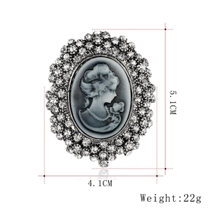 Vintage oval cameo brooch with crystal accents, size 5.1cm by 4.1cm on white background