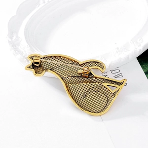 Back view of vintage golden cat brooch showing metal grid texture and pin closure