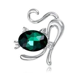 Broche chat argentée mignonne avec un grand cristal vert facetté sur fond blanc pur