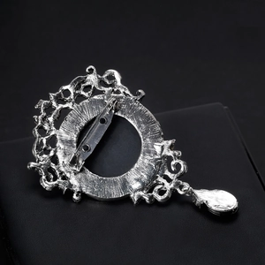 Spilla a rilievo in argento vintage con cornice traforata e ciondolo a goccia retro