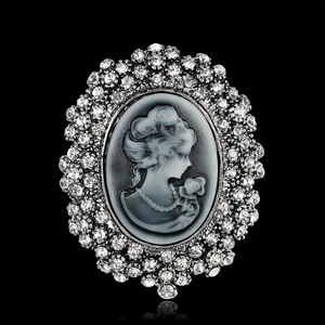 Vintage oval cameo brooch with crystal rhinestones on elegant black mirror background