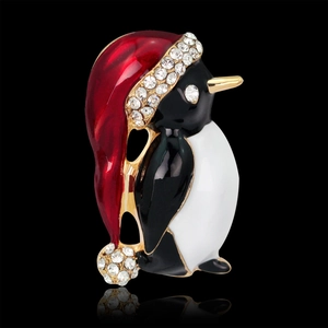 Cute Christmas penguin brooch with red hat and crystals on black background with reflection