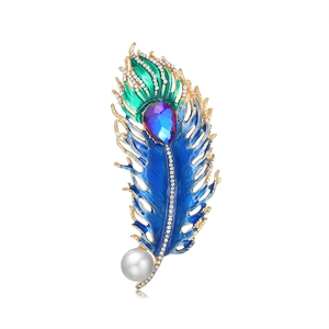 Vintage peacock feather brooch with colorful enamel, crystals, and a large pearl accent