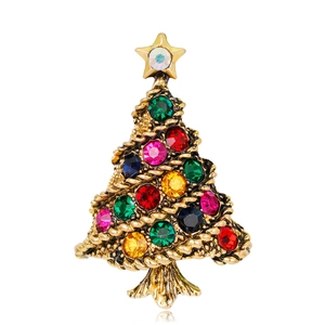 Spilla albero di Natale vintage color oro con strass colorati e stella su sfondo bianco