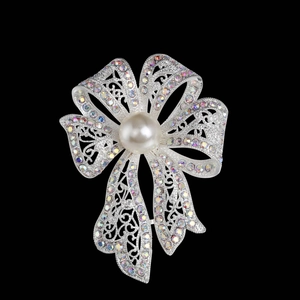 Détail macro d'une broche nœud avec strass étincelants et une grande perle centrale