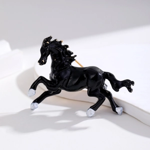 Running horse brooch in black enamel with golden accents on white geometric stand