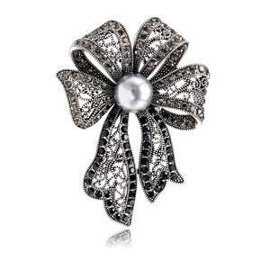 Broche nœud vintage français sertie de strass avec une perle grise centrale