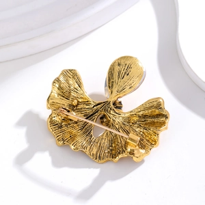 Golden ginkgo leaf brooch with realistic radial textures and a secure safety pin back
