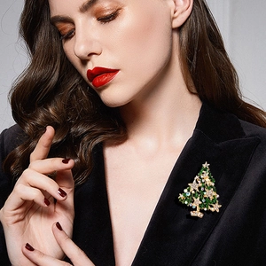 Sparkling Christmas tree brooch with green enamel and rhinestones on dark suit lapel