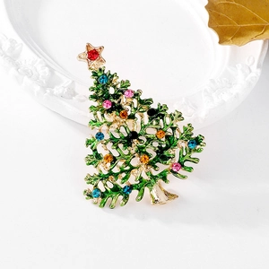 Emaillierte Weihnachtsbaum-Brosche mit bunten Strasssteinen auf weißem Dekotablett