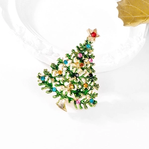 Grüne Emaille-Weihnachtsbaum-Brosche mit bunten Strasssteinen auf weißem Vintage-Teller