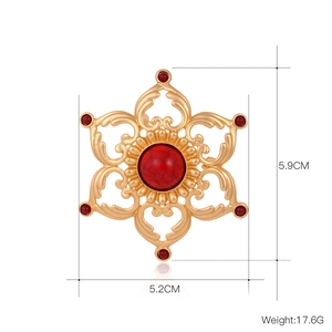 Broche lotus vintage dorée ajourée avec pierre rouge et motif floral ethnique