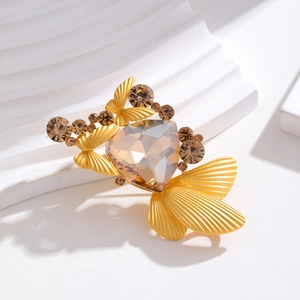 Detail of elegant gold brooch with champagne faceted gem and rhinestone butterfly accents