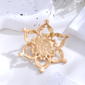 Broche vintage lotus cœur évidé or mat vue arrière sur plateau blanc élégant