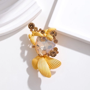 Vintage gold brooch with champagne crystal and butterfly details on a white platform