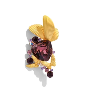 Close-up of a luxury purple crystal butterfly brooch with golden wings and rhinestones