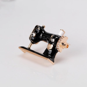 Vintage sewing machine brooch with black enamel and sparkling rhinestones in gold finish