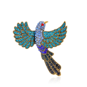 Broche aigle vintage dorée sertie de cristaux bleus et d'un œil en strass rouge vif