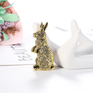 Vintage gold rabbit brooch with textured metal finish on an elegant display