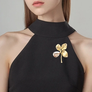Vintage gold four-leaf clover brooch with champagne crystal on black dress