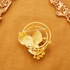 Vintage gold leaf wreath brooch with matte finish and elegant crystal accents on gold metal